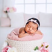 Mavie a rejoint le concours — aidez-le/la à gagner de superbes lots ! baby, newborn, sleeping, pink_bow, headband, blanket, woven_basket, flowers, white_flowers, pink_flowers, soft_light, indoor, cozy, peaceful, infant, cute, portrait, resting, decor, closeup