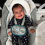 Noah is registered to the contest to win money with this photo: baby, infant, smiling, onesie, stars, baby_seat, elephant, strap, happy, child, indoor, floor, tile, head_support, clothing, person, cute, young, seat, infant_girl