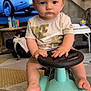 Liam Bedin a rejoint le concours — aidez-le/la à gagner de superbes lots ! baby, barefoot, car_toy, child, clothing, expression, face, floor_rug, foot, furniture, indoor, living_room, person, plastic_toy, shorts, steering_wheel, television, toddler, toy_car, tshirt