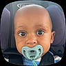 baby, pacifier, car_seat, child, close_up, face, eyes, infant, seatbelt, purple_cushion, cute, toddler, portrait, child_seat, young_child, head, skin, expression, comfort, seat
