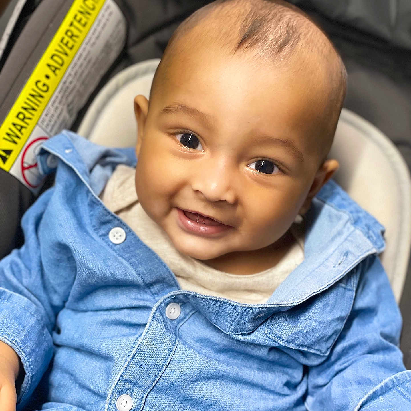 Ahaan is registered to the contest to win money with this photo: baby, baby_boy, buttoned_shirt, car_seat, casual_wear, child, closeup, clothing, cute, denim_shirt, face, happy, indoor, infant, joyful, person, portrait, seated, smile, young_child