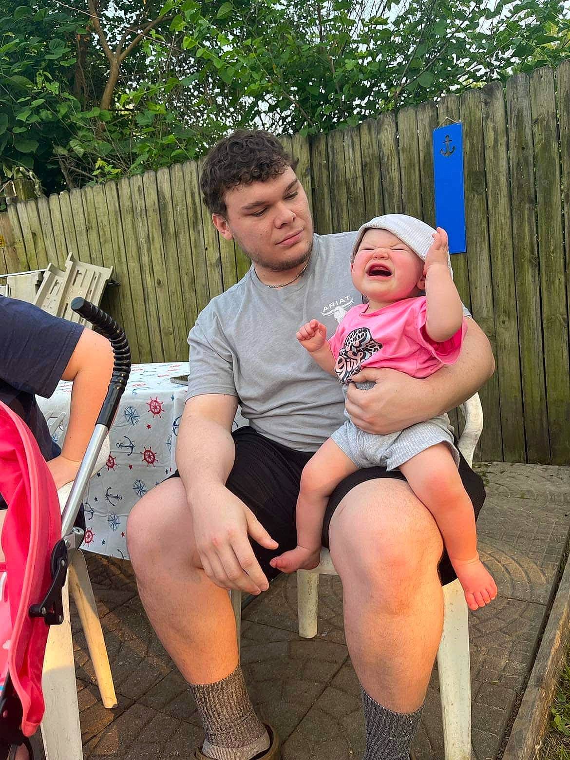 Kynlee is registered to the contest to win money with this photo: facial_expression, fashion, grass, hairstyle, happy, interaction, lap, leg, leisure, mammal, person, pink, plant, recreation, shoe, shorts, sneakers, style, thigh, tree