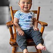 Leonel is registered to the contest to win money with this photo: toddler, child, smiling, wooden_chair, animal_print, shirt, pants, barefoot, indoors, portrait, happy, cute, seated, face, hands, feet, hair, furniture, blurred_background, color_pop