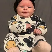 Pearllynn is registered to the contest to win money with this photo: adorable, baby, bow, child, clothing, cow_print, cute, face, happy, headband, indoors, infant, lying_down, onesie, pattern, person, portrait, smile, socks, soft
