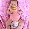 Sofia is registered to the contest to win money with this photo: baby, infant, pink_blanket, pink_onesie, smiling, lying_down, hair_clip, sign, three_months, cute, chubby_legs, child, portrait, soft_texture, indoors, happy, person, newborn, mood, closeup