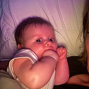 Sofia is registered to the contest to win money with this photo: baby, infant, face, arm, hand, pillow, bed, blanket, person, skin, cheeks, eyes, hair, closeup, indoors, sleepwear, cuteness, snuggle, comfort, rest