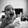 Ezekiel joined the competition — help win amazing prizes! baby, smiling, bottle, hand, lotion, indoor, child, happy, closeup, person, face, holding, young, infant, monochrome, bed, furniture, background, expression, joy