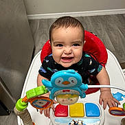 Ezekiel joined the competition — help win amazing prizes! baby, child, smiling, indoor, toy, activity_center, penguin_toy, colorful, happy, floor, clothing, person, play, infant, plastic, seat, cheerful, cute, hands, wood_floor