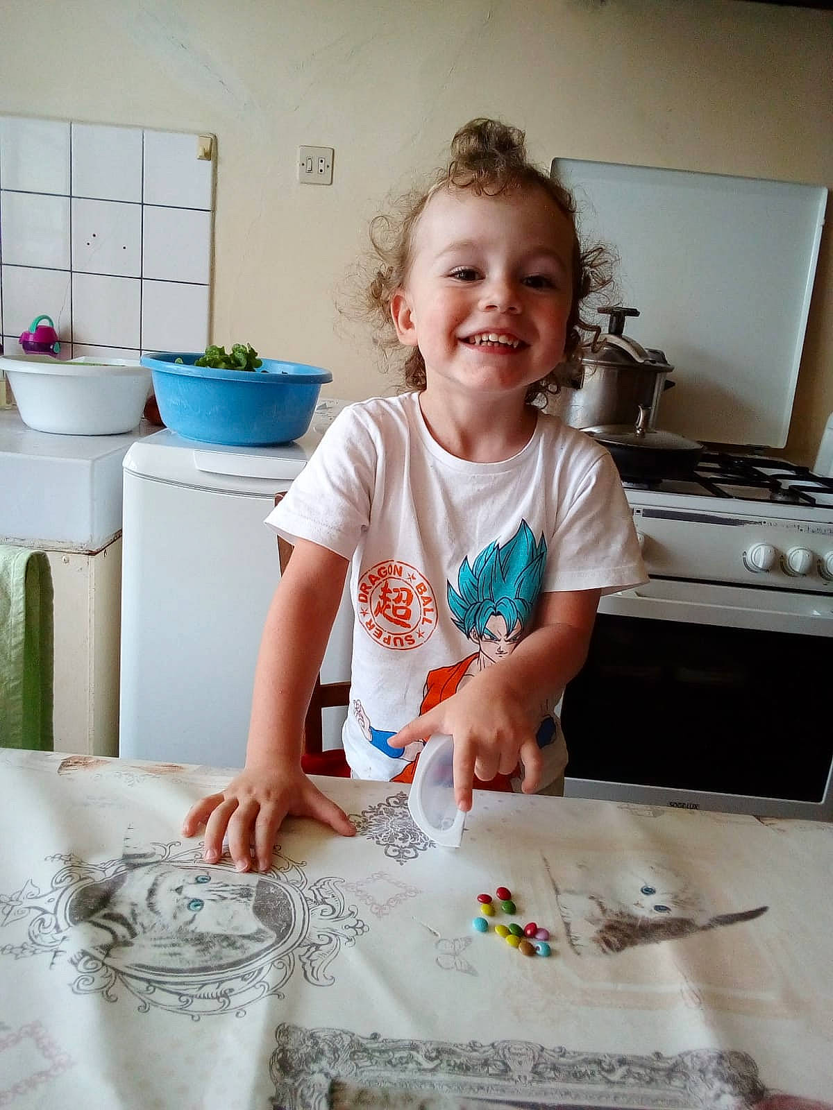 Andy participe au concours pour gagner de l'argent avec cette photo : cabinetry, child, cooking, countertop, flooring, flowerpot, home_appliance, homemaker, houseplant, joy, kitchen, kitchen_appliance, paint, person, plant, play, room, smile, t_shirt, table