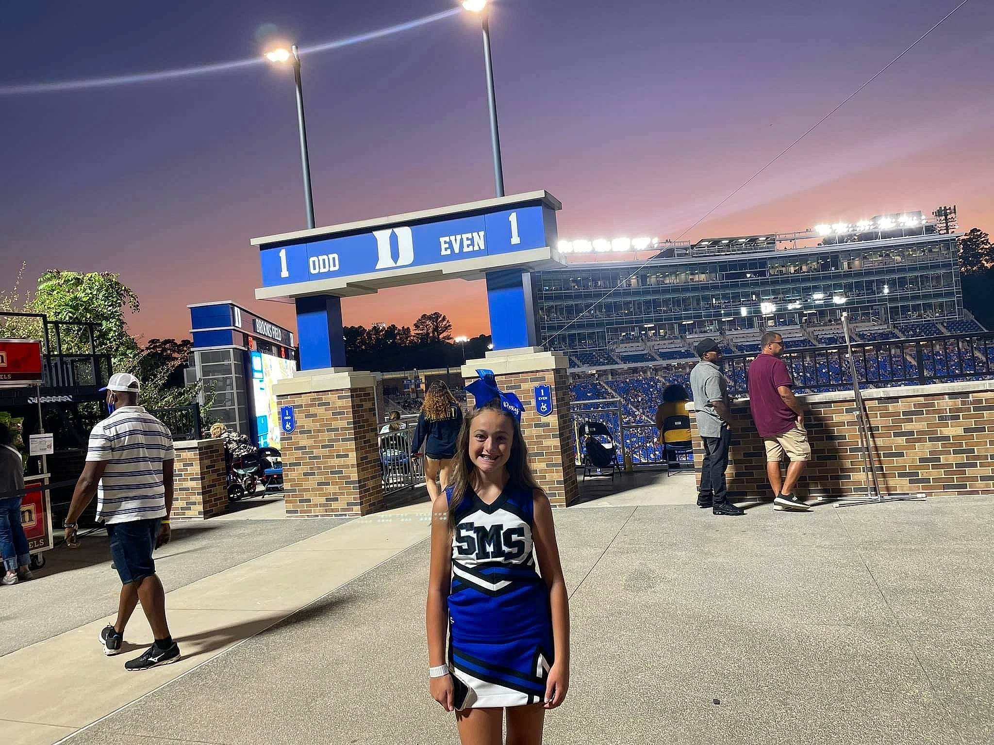 Roxy is registered to the contest to win money with this photo: advertising, city, crowd, electric_blue, electricity, event, flag, fun, joy, leisure, night, pedestrian, person, public_event, recreation, road, sky, street, street_light, t_shirt