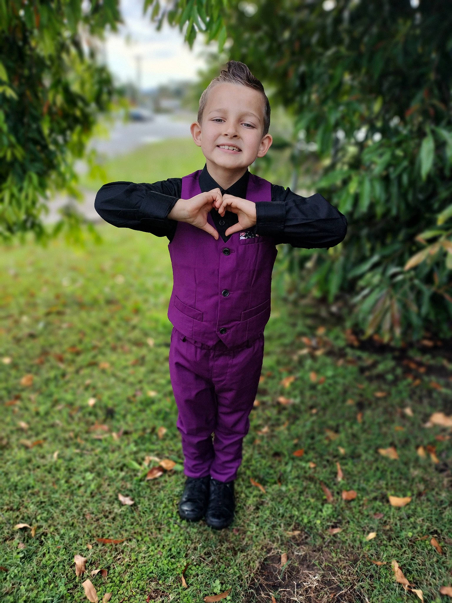 Declan is registered to the contest to win money with this photo: event, face, flash_photography, forest, formal_wear, gesture, grass, happy, joy, leisure, people_in_nature, person, plant, smile, suit, tie, toddler, tree, trousers, tuxedo
