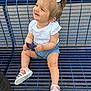 toddler, child, smiling, bench, blue_bench, outdoor, summer_clothing, white_shirt, denim_shorts, pink_sandals, hair_bows, happy, sitting, holding_object, person, cute, sunny, casual, legs, feet