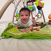Leyth a rejoint le concours — aidez-le/la à gagner de superbes lots ! baby, play_mat, toy, plush_toy, bird_toy, owl_toy, tummy_time, smiling, indoor, floor, colorful, child, person, happy, crawling, clothing, home, cute, infant, playtime