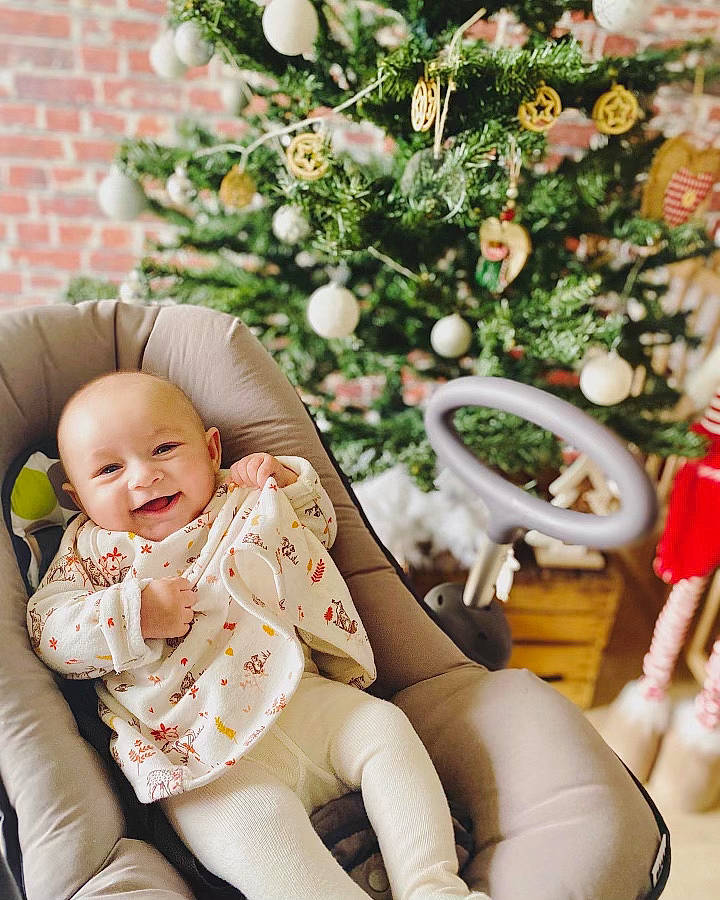 Louise a rejoint le concours — aidez-le/la à gagner de superbes lots ! baby, baby_toddler_clothing, child, christmas_decoration, christmas_ornament, christmas_tree, comfort, event, facial_expression, happy, holiday_ornament, human_leg, joy, knee, lap, leg, ornament, person, sleeve, smile