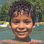 child, boy, smile, water, lake, swimming, curly_hair, outdoor, nature, trees, mountains, summer, sunlight, happy, face, head, person, recreation, holiday, leisure