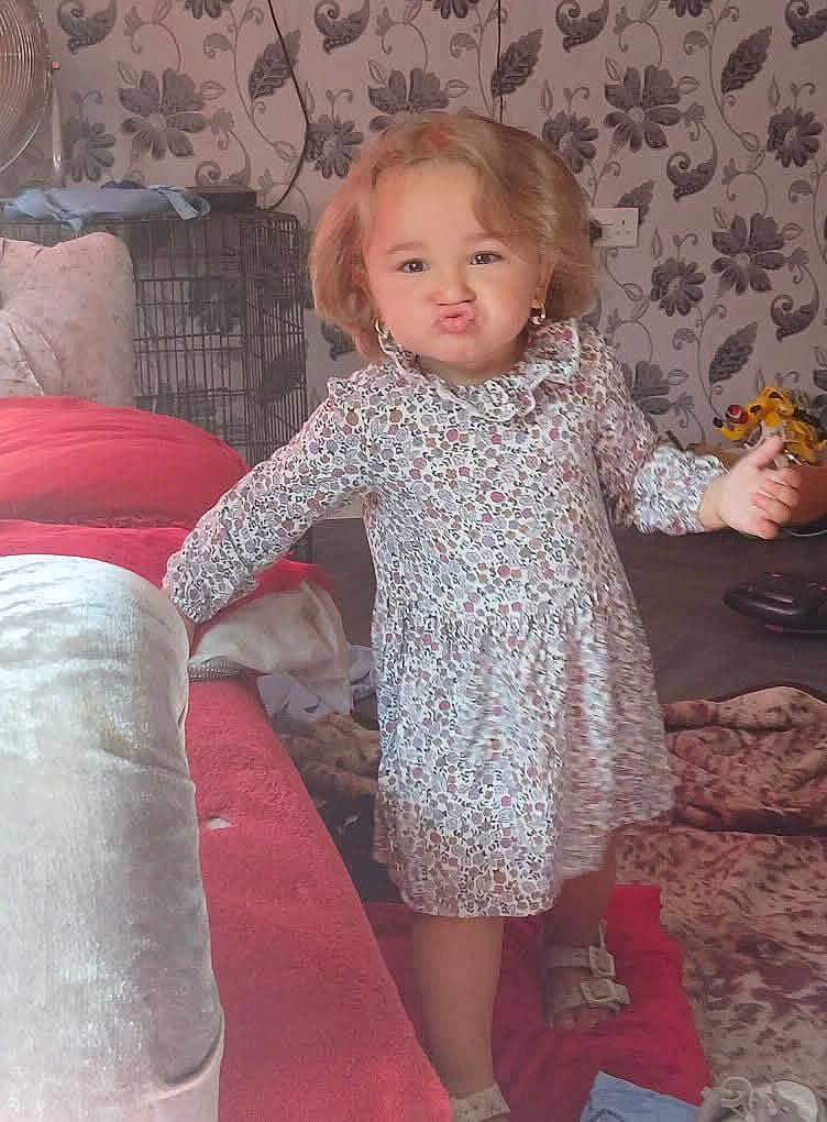 Indiana-Violet joined the competition — help win amazing prizes! carpet, child, couch, curly_hair, cute, earrings, expression, floor, floral_dress, footwear, furniture, home, indoor, living_room, pattern, person, pout, standing, toy, wallpaper