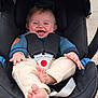 baby, child, car_seat, smiling, happy, infant, safety_harness, clothing, blue_sweater, beige_pants, barefoot, cute, outdoor, seat, infant_face, joy, hands, feet, skin, person