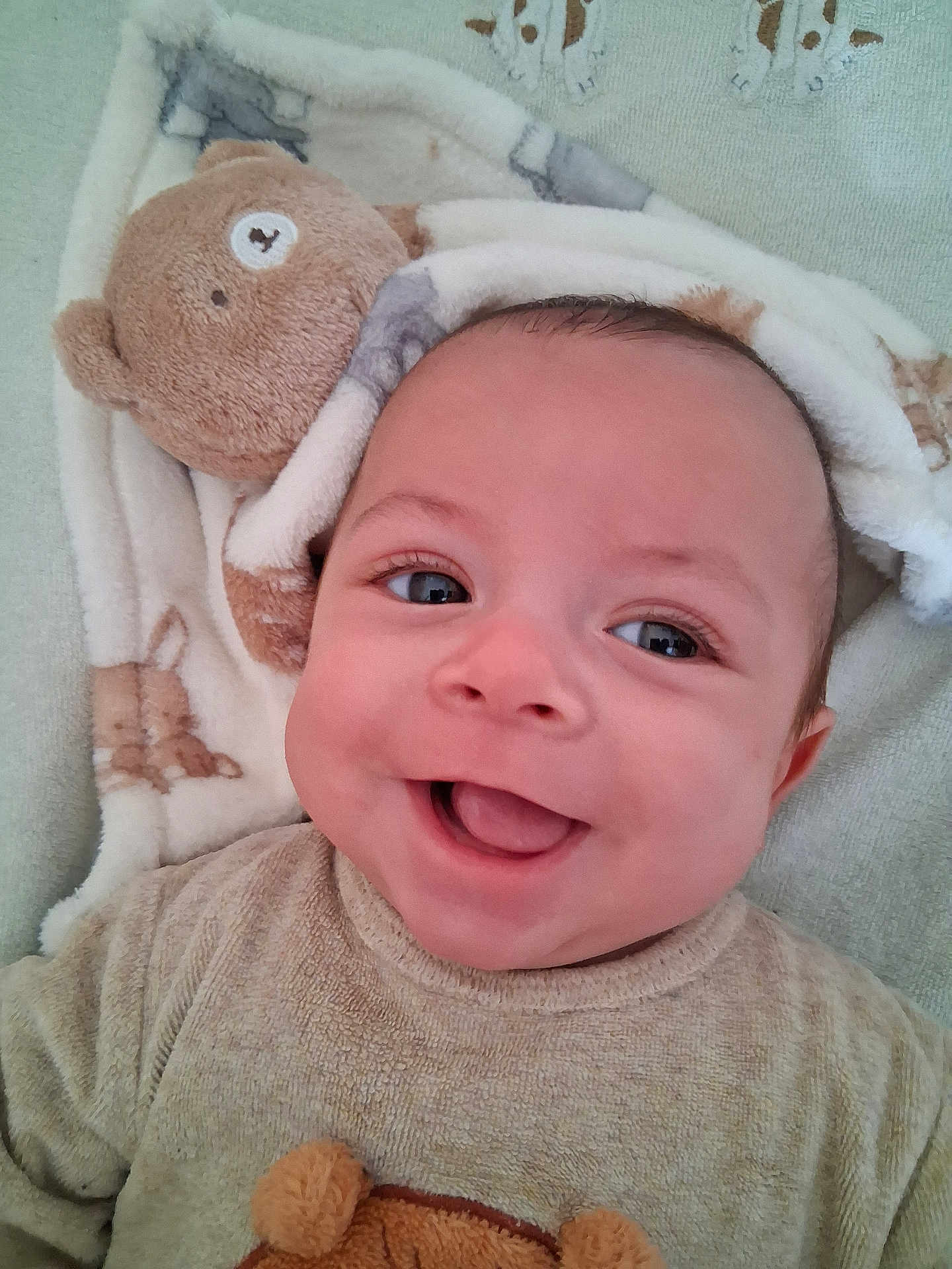 Aylane participe au concours pour gagner de l'argent avec cette photo : baby, infant, smile, tongue, blanket, teddy_bear, plush_toy, cute, portrait, closeup, face, eyes, cheeks, clothing, soft_texture, lying_down, happy, newborn, skin, head