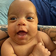Mariah joined the competition — help win amazing prizes! baby, infant, smile, happy, face, arms, tattoo, skin, bed, pillow, indoor, person, child, cute, closeup, expression, newborn, human, portrait, joy