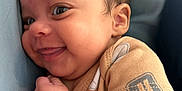 Mariah is registered to the contest to win money with this photo: baby, smile, face, child, infant, cute, skin, clothing, arm, hand, cheek, happy, portrait, closeup, person, young, cute_face, cozy, lying_down, expression