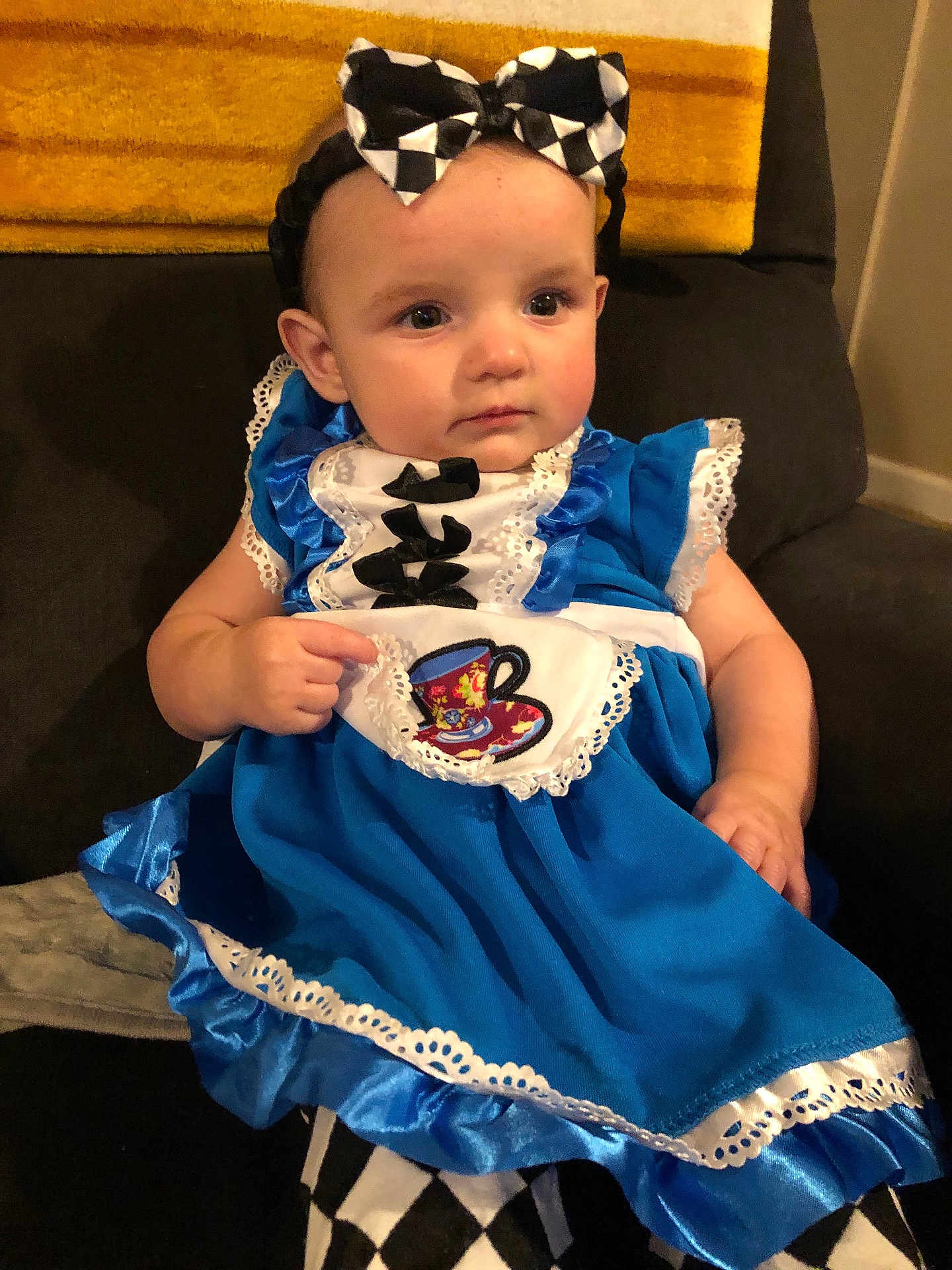Haven is registered to the contest to win money with this photo: baby, child, dress, blue_dress, headband, bow, teacup_patch, sitting, couch, blanket, indoor, curious, cute, portrait, person, face, chubby_cheeks, expression, black_and_white, fabric