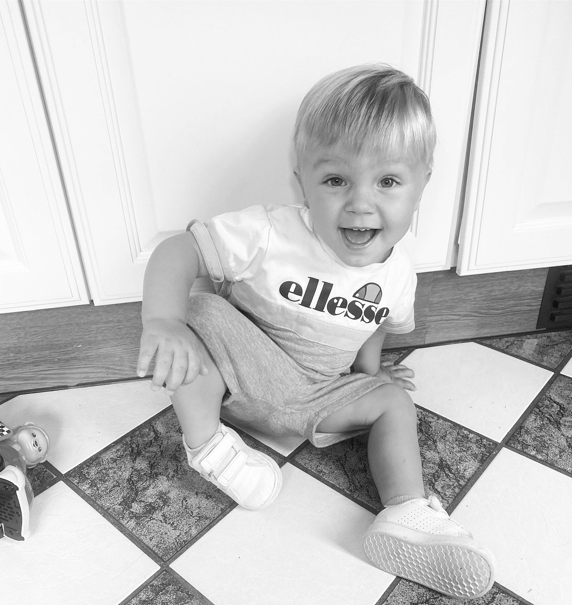 Amaury participe au concours pour gagner de l'argent avec cette photo : baby_toddler_clothing, black, black_and_white, child, floor, flooring, fun, knee, monochrome, monochrome_photography, person, shorts, sitting, sleeve, smile, snapshot, style, t_shirt, toddler, white