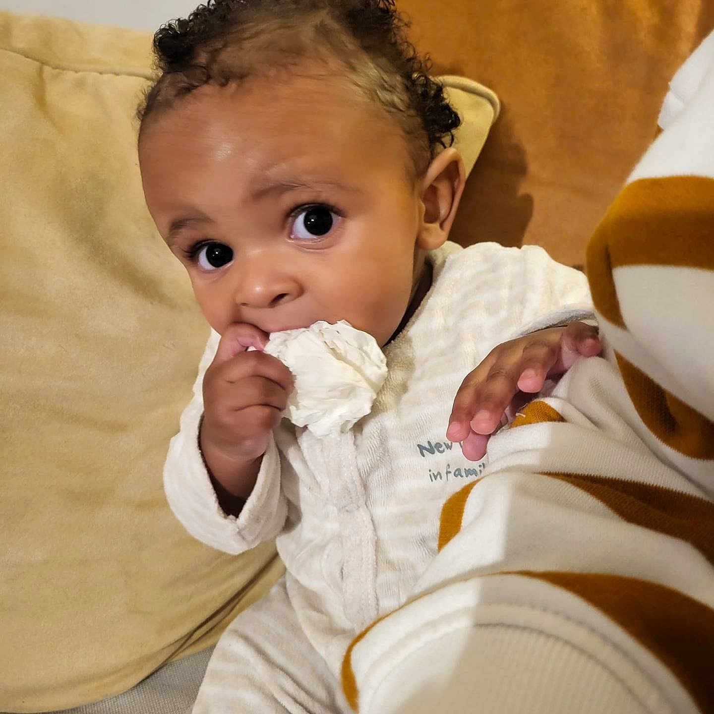 Tymothée participe au concours pour gagner de l'argent avec cette photo : baby, blanket, child, clothing, comfort, couch, cozy, curly_hair, cushion, cute, expression, eyes, face, hand, indoors, infant, portrait, sitting, tissue, young