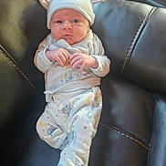 Chance joined the competition — help win amazing prizes! baby, infant, hat, ears, pajamas, cartoon, stars, black_leather, chair, hand, footwear, sock, person, cute, indoors, portrait, young_child, expression, clothing, seated