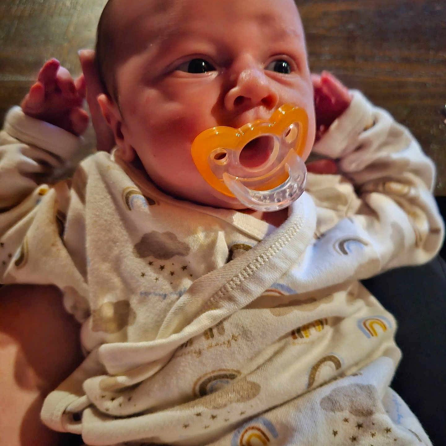 Chance joined the competition — help win amazing prizes! baby, pacifier, onesie, infant, hand, wooden_background, clothing, face, newborn, cute, portrait, closeup, child, sleepwear, human, soft_lighting, indoors, expression, holding, resting