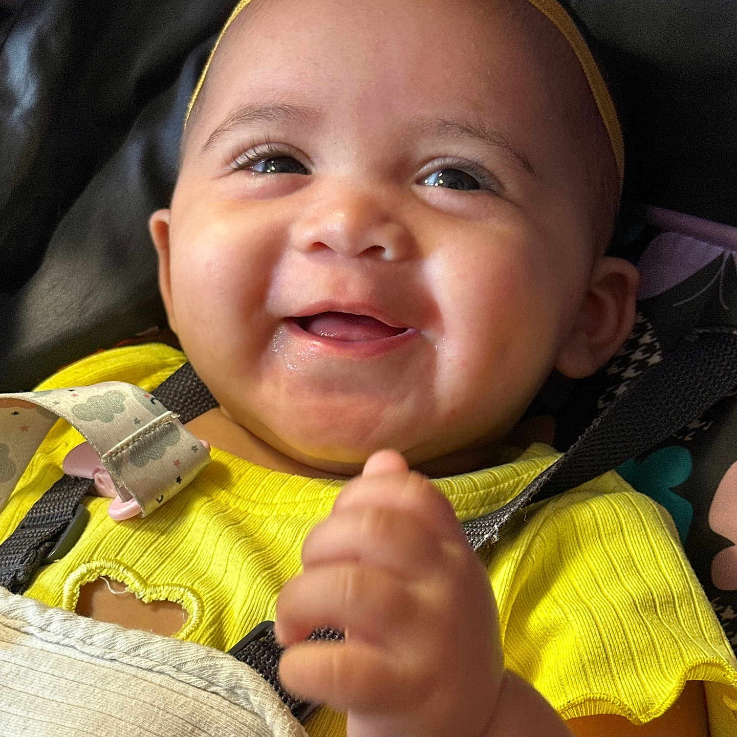Jewelyah is registered to the contest to win money with this photo: baby, car_seat, child, closeup, cute, emotion, expression, face, hand, happy, headwear, indoors, infant, portrait, seatbelt, skin, smiling, yellow_clothing, yellow_headband, young_child