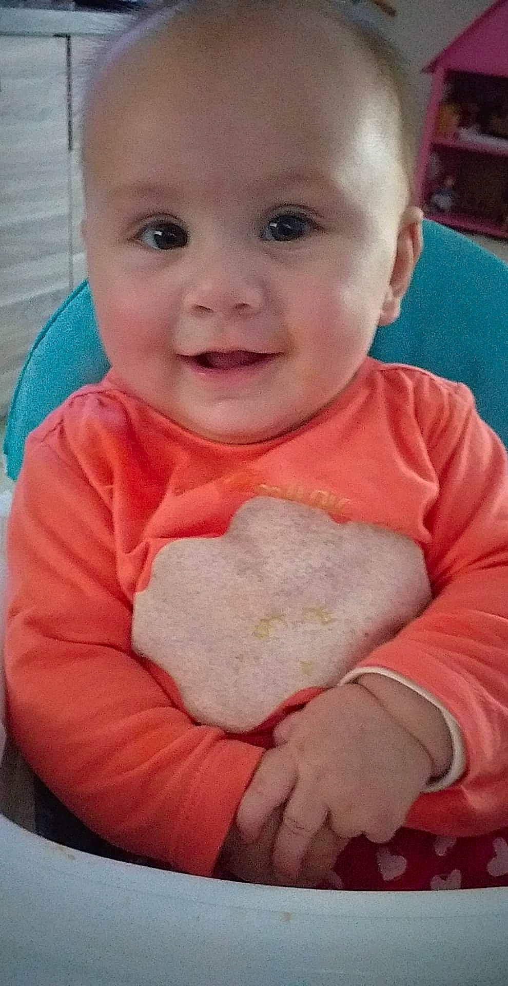 Emma a rejoint le concours — aidez-le/la à gagner de superbes lots ! baby, baby_toddler_clothing, cheek, child, comfort, gesture, happy, head, iris, linens, lip, mouth, nose, person, pink, sitting, skin, sleeve, smile, t_shirt