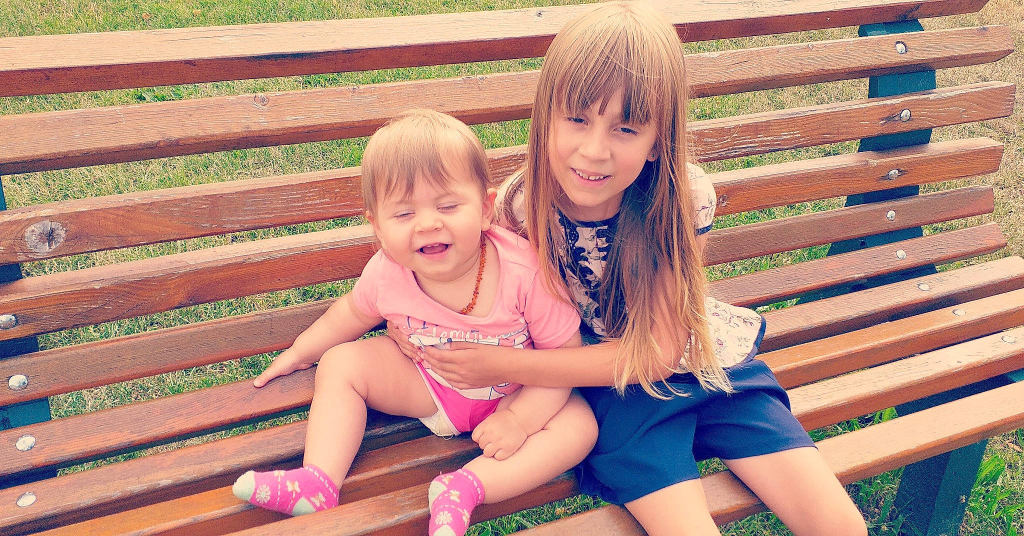 Mélina a rejoint le concours — aidez-le/la à gagner de superbes lots ! beauty, blond, child, facial_expression, friendship, fun, grass, happy, joy, leg, people, person, pink, play, sibling, sitting, skin, smile, snapshot, summer