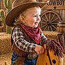 Aries joined the competition — help win amazing prizes! child, toddler, cowboy_hat, bandana, plaid_shirt, vest, jeans, wooden_rocking_horse, western_theme, hay, cactus, wooden_wheel, barrel, smiling, portrait, indoor, costume, cute, playful, decor