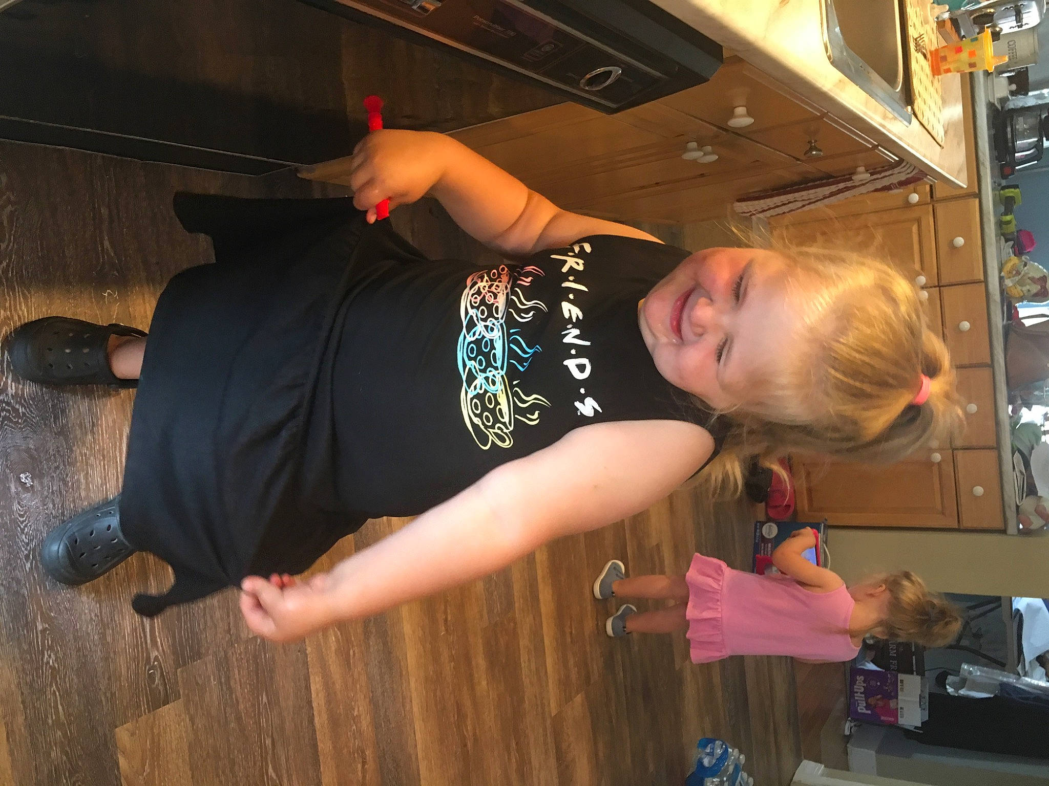 Bayley is registered to the contest to win money with this photo: audio_equipment, door, elbow, flash_photography, flooring, fun, hardwood, home_appliance, human_leg, joint, joy, kitchen, machine, person, room, shoulder, sportswear, standing, t_shirt, toddler