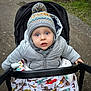 Léo participe au concours pour gagner de l'argent avec cette photo : baby, child, stroller, hat, pom_pom, jacket, blanket, outdoor, path, curious, blue_eyes, winter_clothing, knitwear, person, infant, cute, cold_weather, nature, bundle_up, colorful