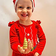 Lisa participe au concours pour gagner de l'argent avec cette photo : child, smile, red_clothing, santa_hat, christmas, holiday, golden_tree, ornament, festive, happy, portrait, long_sleeve, tutu, indoor, person, celebration, cute, young_child, holiday_season, bright