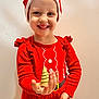 child, smile, red_clothing, santa_hat, christmas, holiday, golden_tree, ornament, festive, happy, portrait, long_sleeve, tutu, indoor, person, celebration, cute, young_child, holiday_season, bright