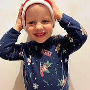 Lisa a rejoint le concours — aidez-le/la à gagner de superbes lots ! background, celebration, child, christmas_sweater, clothing, cute, festive_hat, happy, headwear, holiday, indoor, joyful, person, portrait, red_hat, seasonal, smiling, sweater, winter, young_child