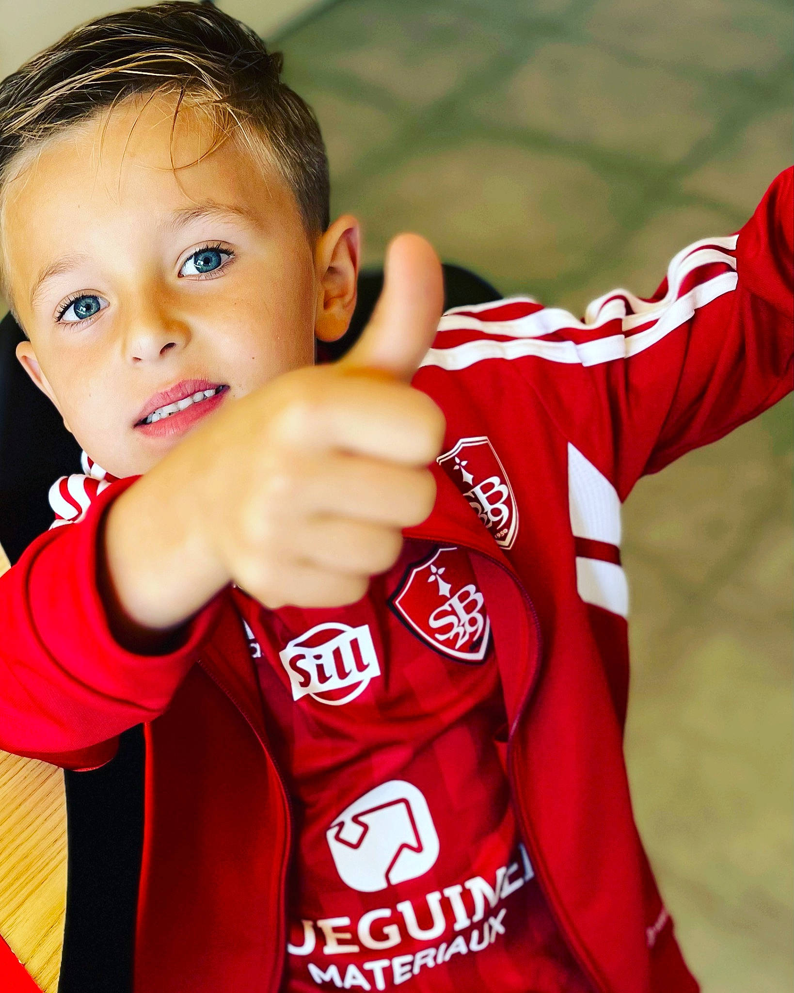 Adem a rejoint le concours — aidez-le/la à gagner de superbes lots ! baby_toddler_clothing, carmine, finger, fun, gesture, happy, jersey, person, play, player, sleeve, smile, sports, sports_jersey, sports_uniform, sportswear, t_shirt, team_sport, thumb, toddler