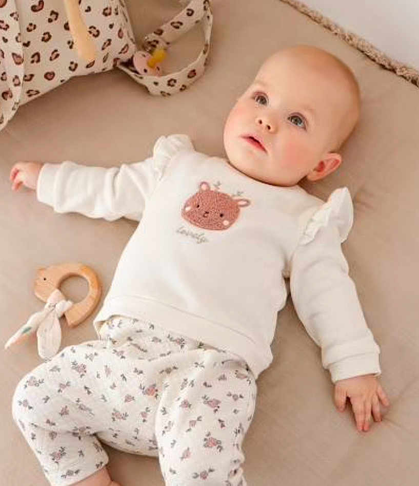 Kélya a rejoint le concours — aidez-le/la à gagner de superbes lots ! baby, infant, child, lying_down, white_clothing, animal_print, floral_pattern, wooden_toy, teething_ring, soft_surface, beige_background, cute, innocent, gazing_up, cozy, comfortable, indoor, portrait, young_child, peaceful