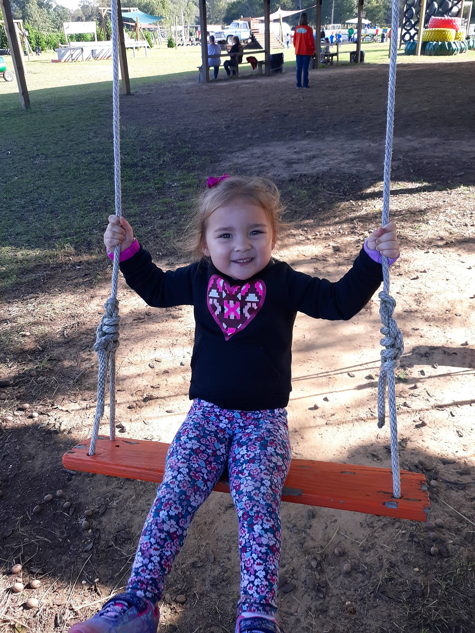 Alanah is registered to the contest to win money with this photo: child, city, fun, human_settlement, joy, outdoor_play_equipment, park, person, play, playground, public_space, recreation, smile, swing, toddler, tree