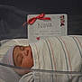 Nova is registered to the contest to win money with this photo: newborn, baby, sleeping, hospital, blanket, striped, cap, bassinet, infant, birth_announcement, card, red_bow, face, headwear, cute, wrapped, peaceful, indoors, portrait, child