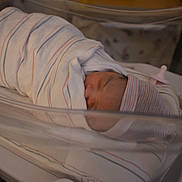 Nova is registered to the contest to win money with this photo: newborn, baby, hospital, blanket, bassinet, pacifier, sleeping, infant, wrapped, hat, bed, medical, cute, child, person, healthcare, inside, resting, soft, peaceful