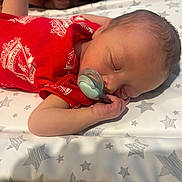 Reggie is registered to the contest to win money with this photo: newborn, baby, infant, sleeping, pacifier, red_clothing, liverpool, football_club, blanket, stars, hand, face, head, skin, cute, peaceful, resting, indoors, portrait, child