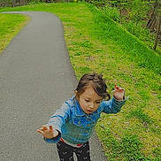 Sylvia is registered to the contest to win money with this photo: child, toddler, denim_jacket, patterned_pants, pink_shoes, paved_path, green_grass, trees, forest, outdoor, nature, walking, curious, motion, heart_emoji, casual_clothing, daylight, young_child, cute, playful