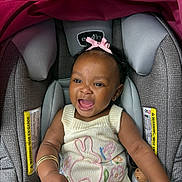 Star is registered to the contest to win money with this photo: accessory, baby, bracelet, bunny_design, car_seat, child, clothing, cute, flower_design, happy, headwear, indoor, infant, knitted_outfit, person, pink_bow, portrait, seatbelt_warning, skin, smiling