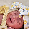 baby, newborn, smiling, closeup, headband, flower_pattern, yellow_clothing, blanket, infant, cute, peaceful, sleeping, skin, hand, portrait, soft_texture, happy, child, resting, indoors