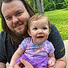 adult, baby, child, smile, outdoor, nature, greenery, grass, trees, tattoo, purple_tutu, short_sleeves, holding, happy, face, person, portrait, casual_clothing, beard, long_hair