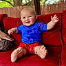 baby, child, smiling, red_couch, blue_shirt, red_shorts, barefoot, outdoor, fence, tree, person, sitting, happy, cute, infant, portrait, hand, foot, skin, cushion
