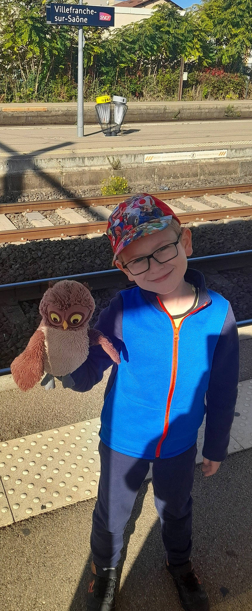 Kenzo a rejoint le concours — aidez-le/la à gagner de superbes lots ! asphalt, cap, child, electric_blue, eyewear, fashion_accessory, fun, grass, headwear, joy, leisure, owl, parrot, person, personal_protective_equipment, plush, recreation, smile, soil, stuffed_toy